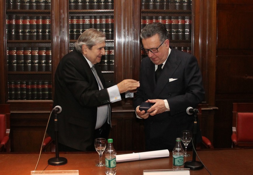 El vicedecano Alberto Bueres entrega el diploma y la medalla que acreditan a Miguel Herrero y Rodríguez de Miñón como doctor honoris causa de la UBA.